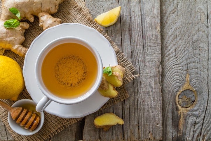 Ginger tea and ingredients on rustic wood background